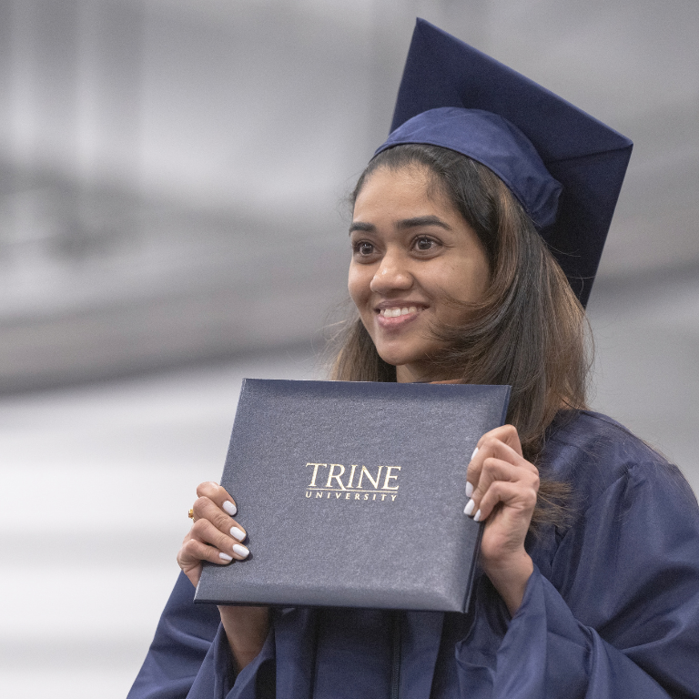 graduate holding a trine university degree at commencement